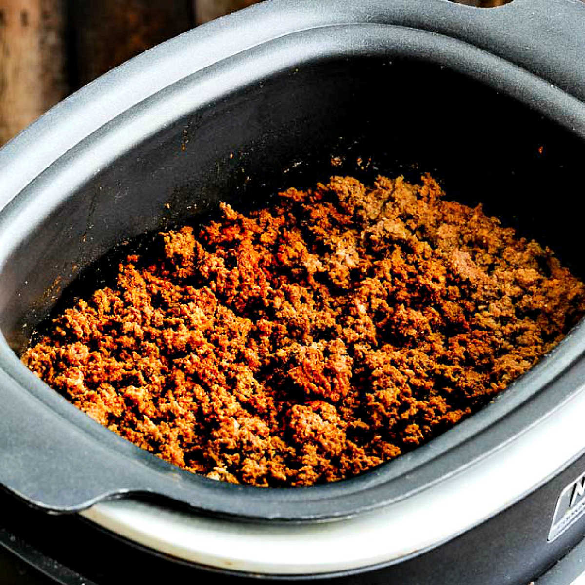Square image of Slow Cooker Taco Meat with cooked meat shown in slow cooker.