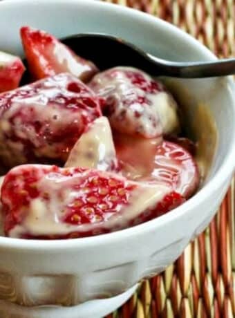 Square image of Strawberries Romanoff shown in serving dish with spoon.