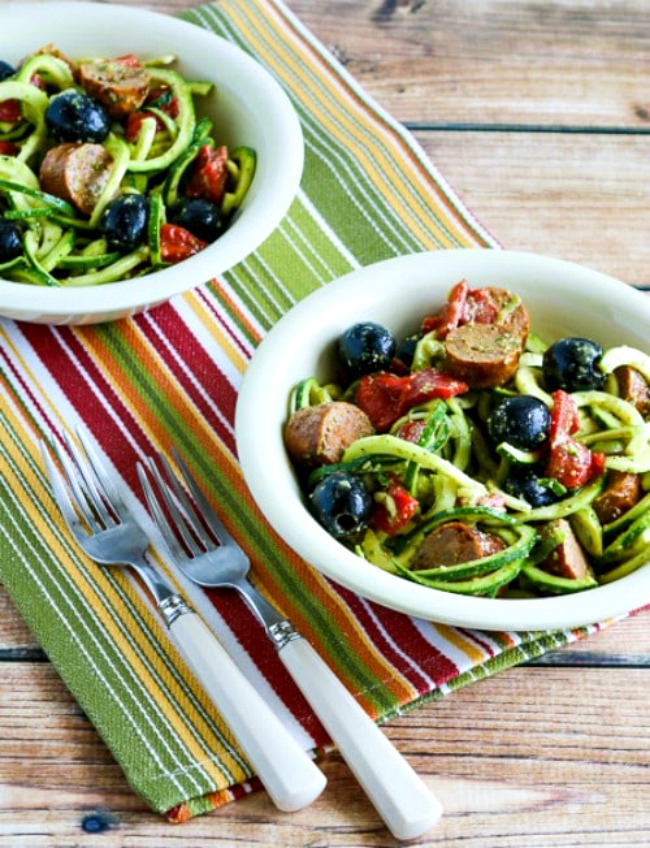 Zucchini Noodle Mock Pasta Salad show in two serving bowls on striped napkin with forks