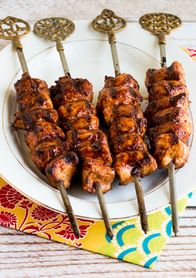 Sriracha-Glazed Grilled Chicken Kabobs shown with four kabobs on serving plate