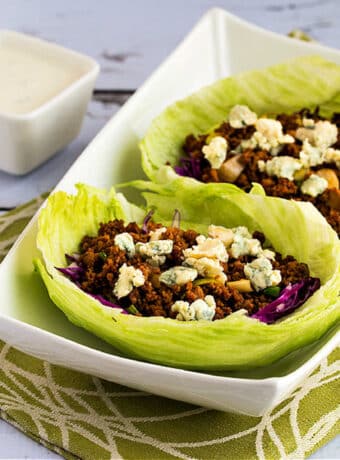 Square image of Buffalo Chicken or Turkey Lettuce Wraps in serving dish on green-white-napkin.