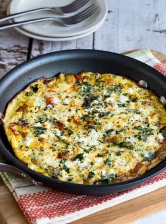Greek Frittata shown in frittata pa on napkin and cutting board