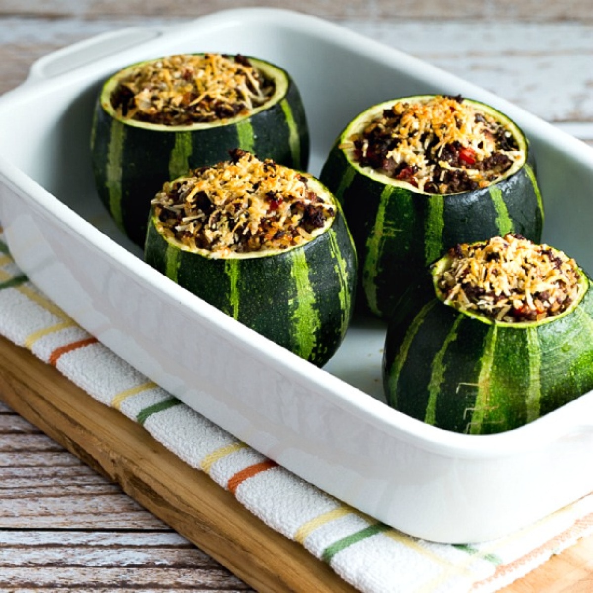 square image of Stuffed Zucchini with Ground Beef shown in baking dish