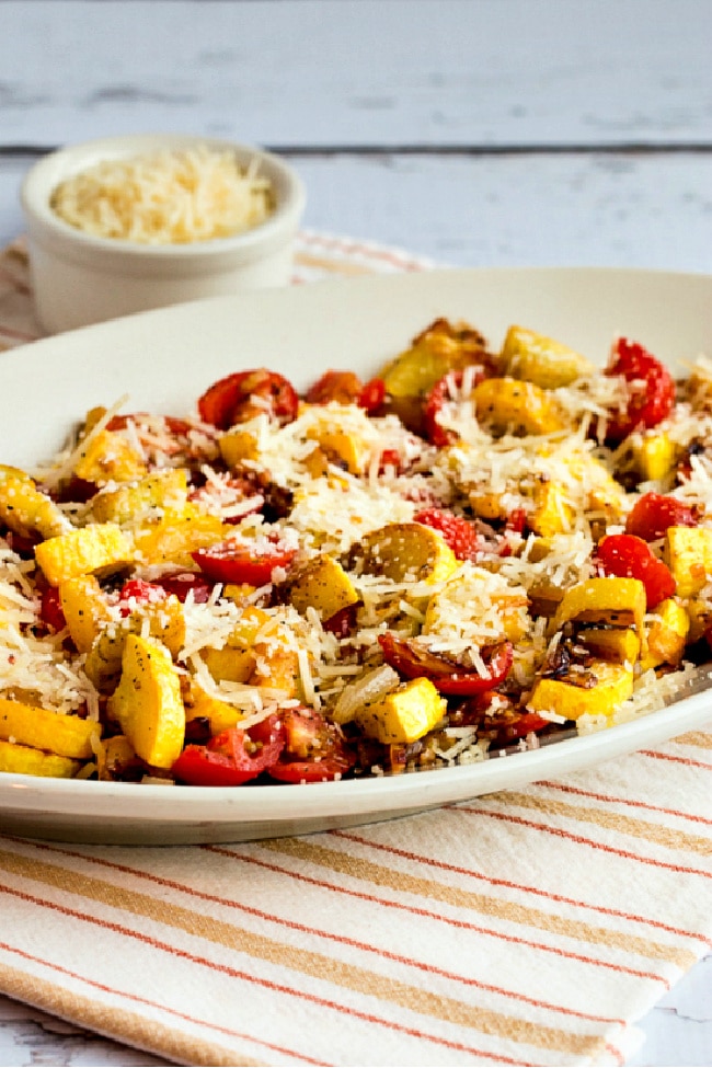 Val's Easy Yellow Squash with Tomatoes and Parmesan on serving plate with Parmesan cheese