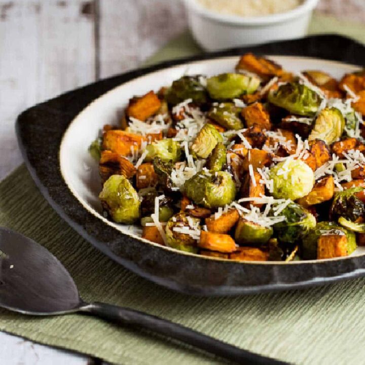 Sweet Potatoes and Brussels Sprouts shown on serving plate with Parmesan in background