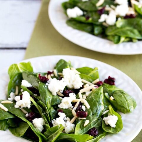Spinach Salad with Cranberries, Almonds, and Goat Cheese finished salads on plates