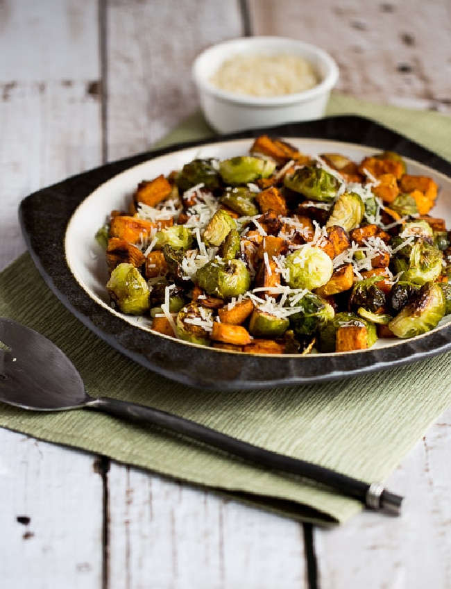 Sweet Potatoes and Brussels Sprouts on serving plate with Parmesan in background