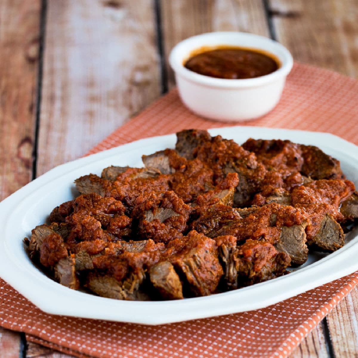 Slow Cooker Sweet and Sour Beef on serving platter with sauce in back.