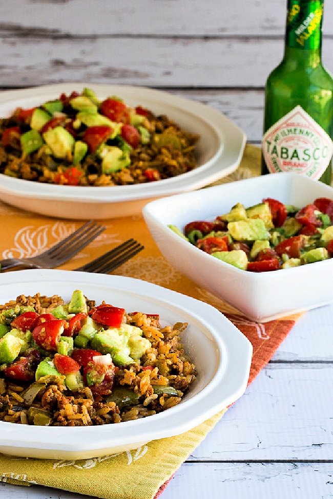 Slow Cooker Turkey Taco Bowls shown in two bowls with salsa and Green Tabasco Sauce on side.