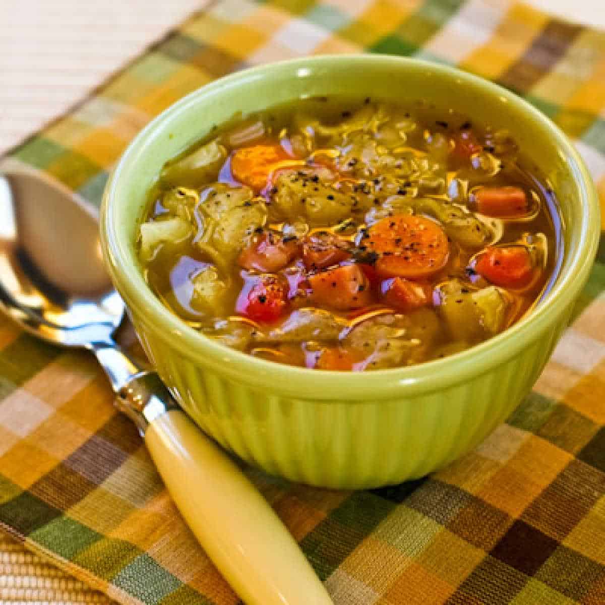 Slow Cooker Ham and Cabbage Soup square image of soup in bowl with spoon
