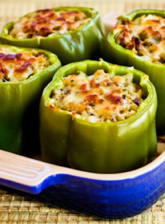 Stuffed Green Peppers with Brown Rice, Italian Sausage, and Parmesan shown in baking dish.