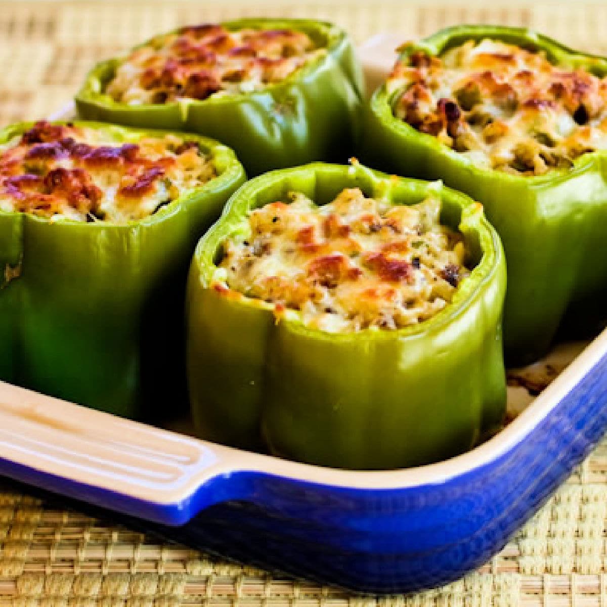 Stuffed Green Peppers with Brown Rice, Italian Sausage, and Parmesan shown in baking dish.