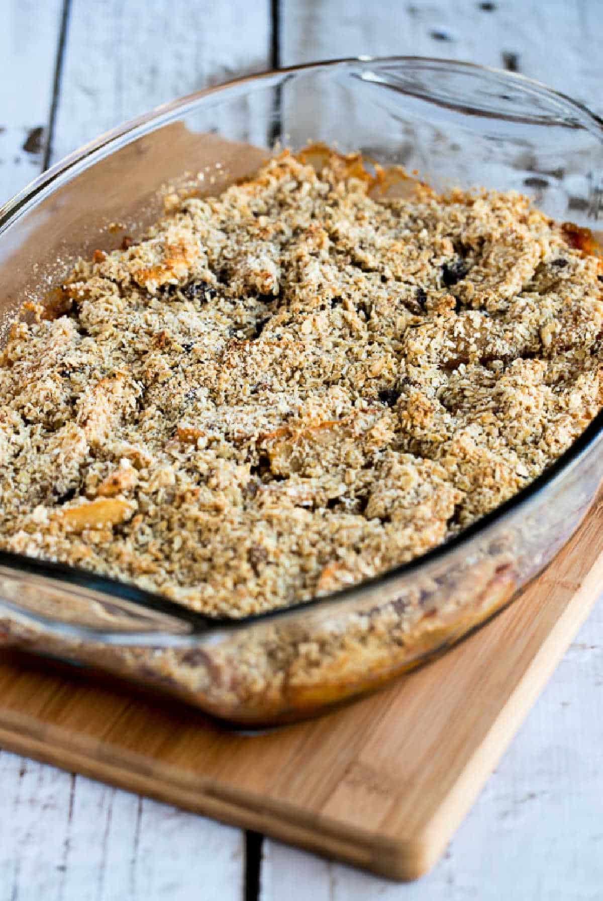 Cranberry apple crumble presented in a baking dish on a cutting board