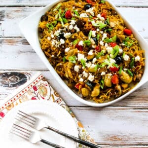 Mediterranean Spaghetti Squash with Vegetables and Feta shown on serving platter with plates and forks.