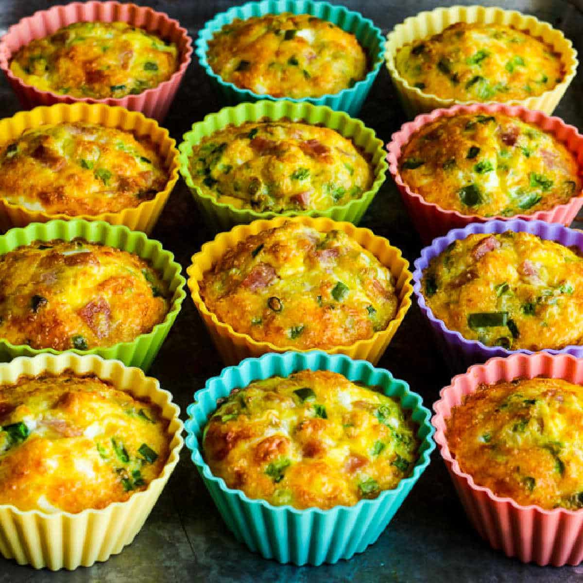 Egg Muffins with Ham, Cheese, and Bell Pepper shown in silicone baking cups on baking sheet.