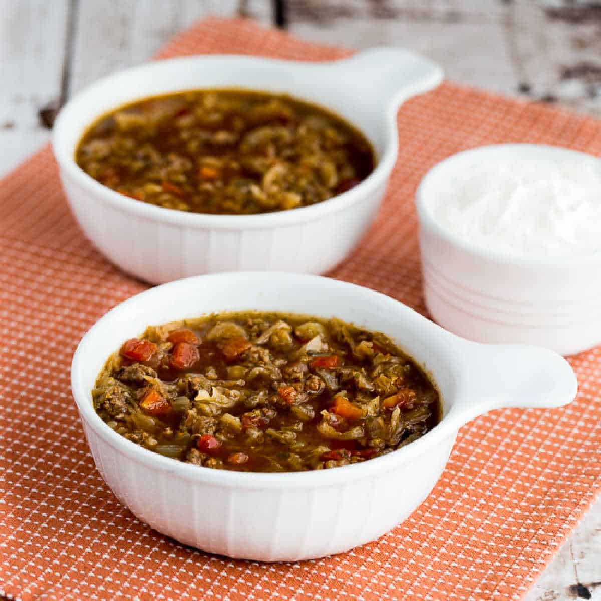 Ground Beef and Sauerkraut Soup shown in two bowls with sour cream.