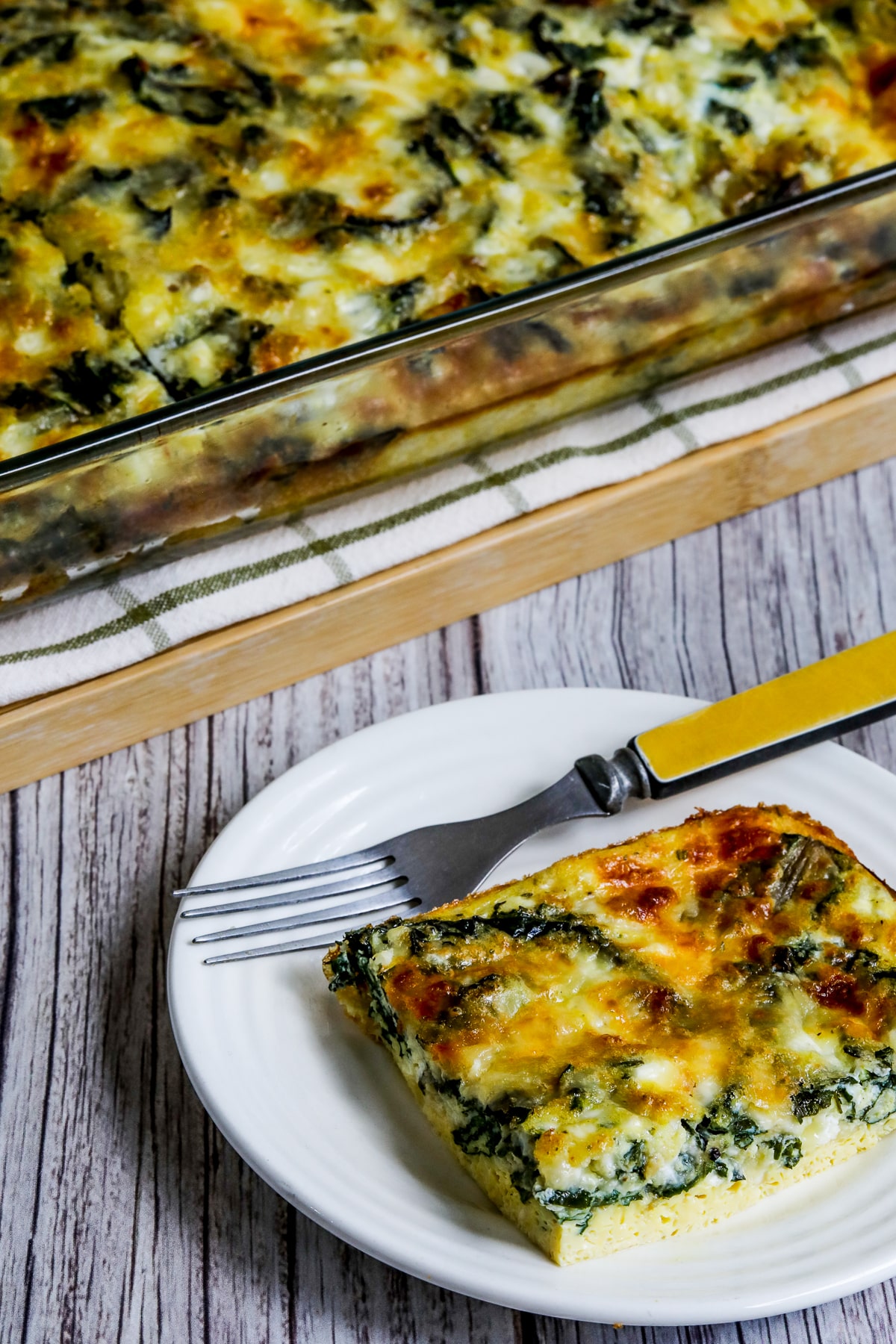 Swiss Chard Egg Bake (with Cottage Cheese) shown with one piece on small plate and casserole dish in back.