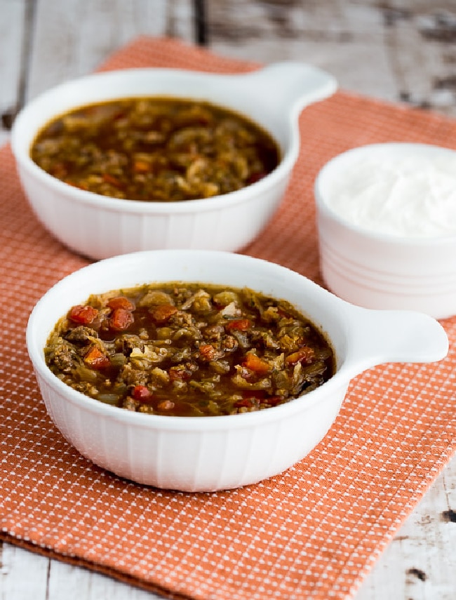 Ground Beef and Sauerkraut Soup shown in two serving bowls with sour cream