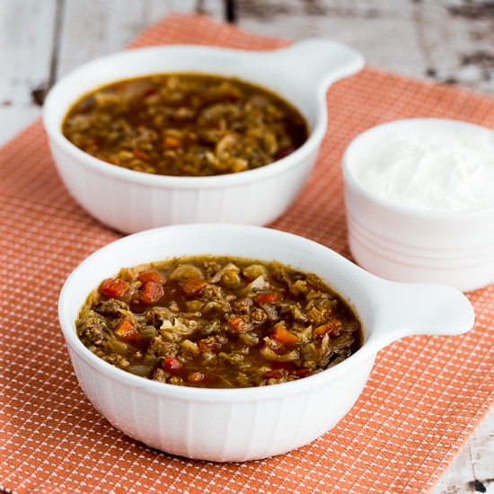 Ground Beef and Sauerkraut Soup in soup bowls with sour cream