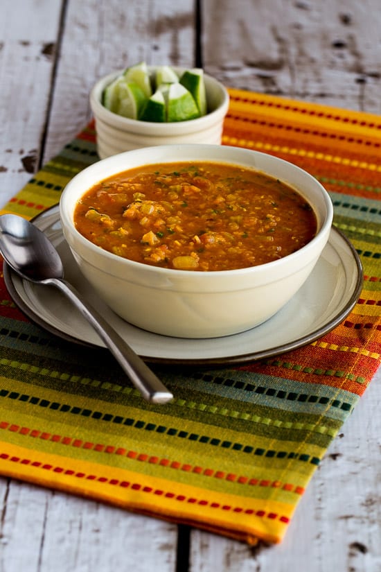 Mexican Red Lentil Stew shown on napkin with cut limes in background.