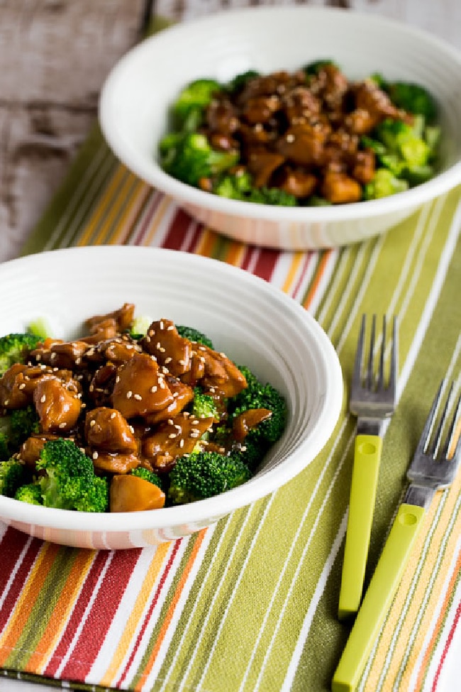 Slow Cooker Asian Chicken shown in two bowls served as a bowl meal with broccoli.