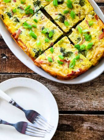 Square image for Slow Cooker Breakfast Casserole with Broccoli, Ham, and Swiss shown on serving platter.