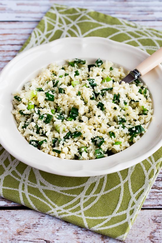 Easy Cauliflower Rice with Garlic and Green Onion shown in serving bowl with spoon