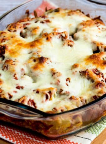 Square image of Meatball Casserole with Artichokes shown in baking dish with melted cheese.