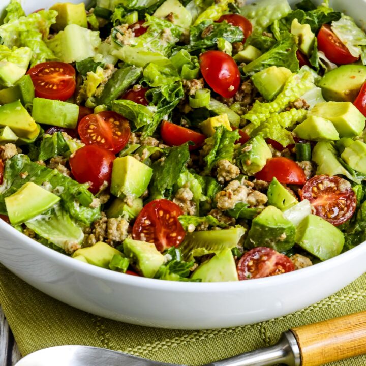 Ground Turkey Taco Salad with Salsa Verde shown in serving bowl with spoon.