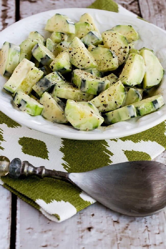 Cucumbers Caesar on serving plate with serving spoon and napkin