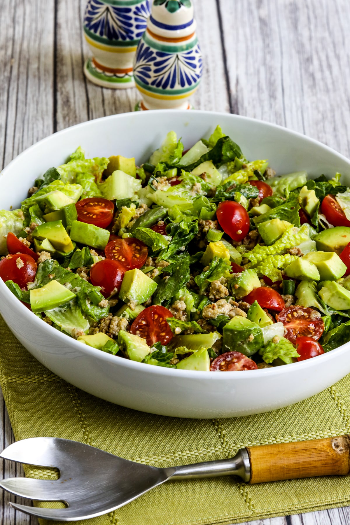 Ground Turkey Taco Salad with Salsa Verde shown in bowl on green napkin.