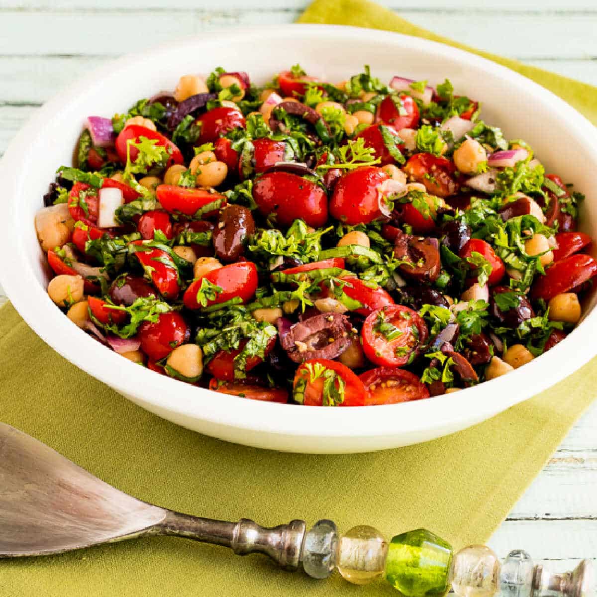 Chickpea Salad with Tomatoes and Olives shown in serving bowl.