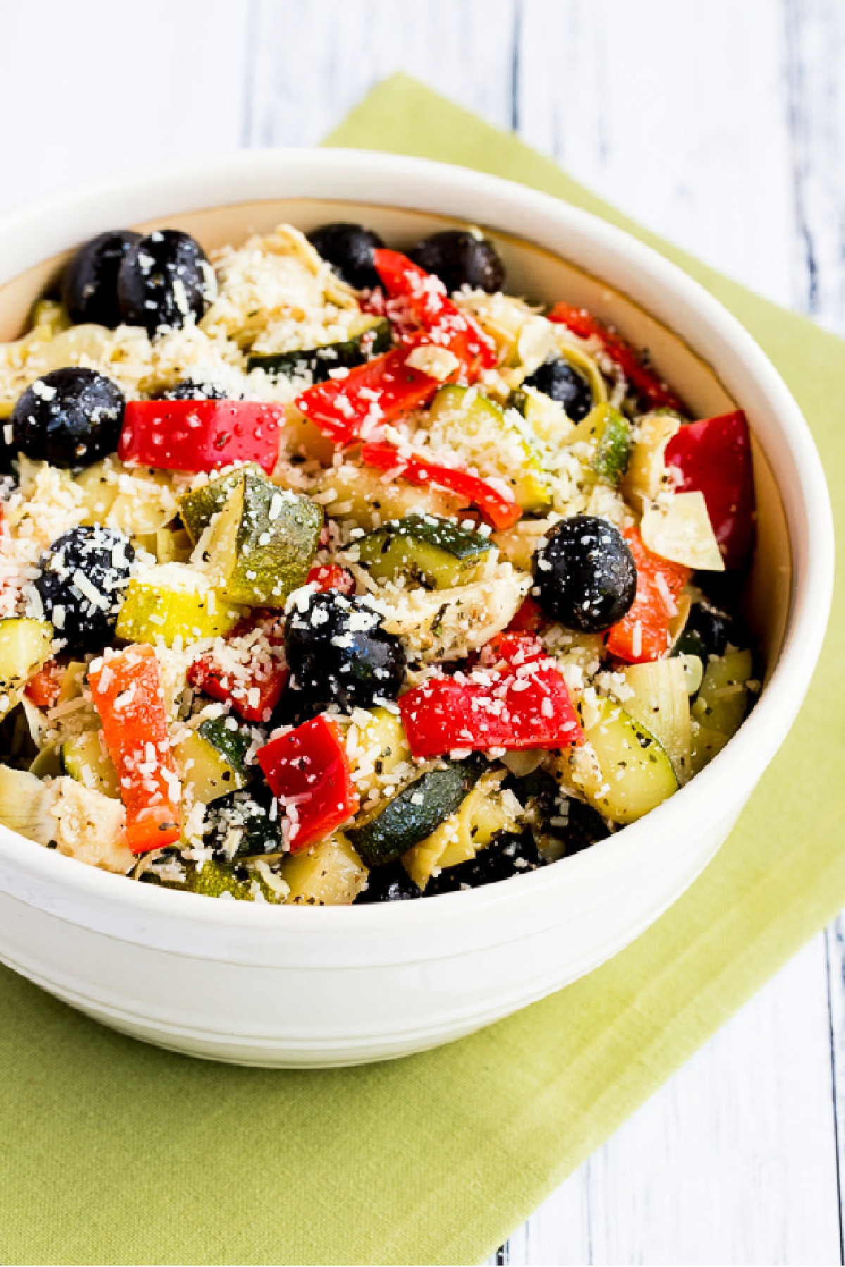 Marinated Zucchini Salad shown in serving bowl on green napkin