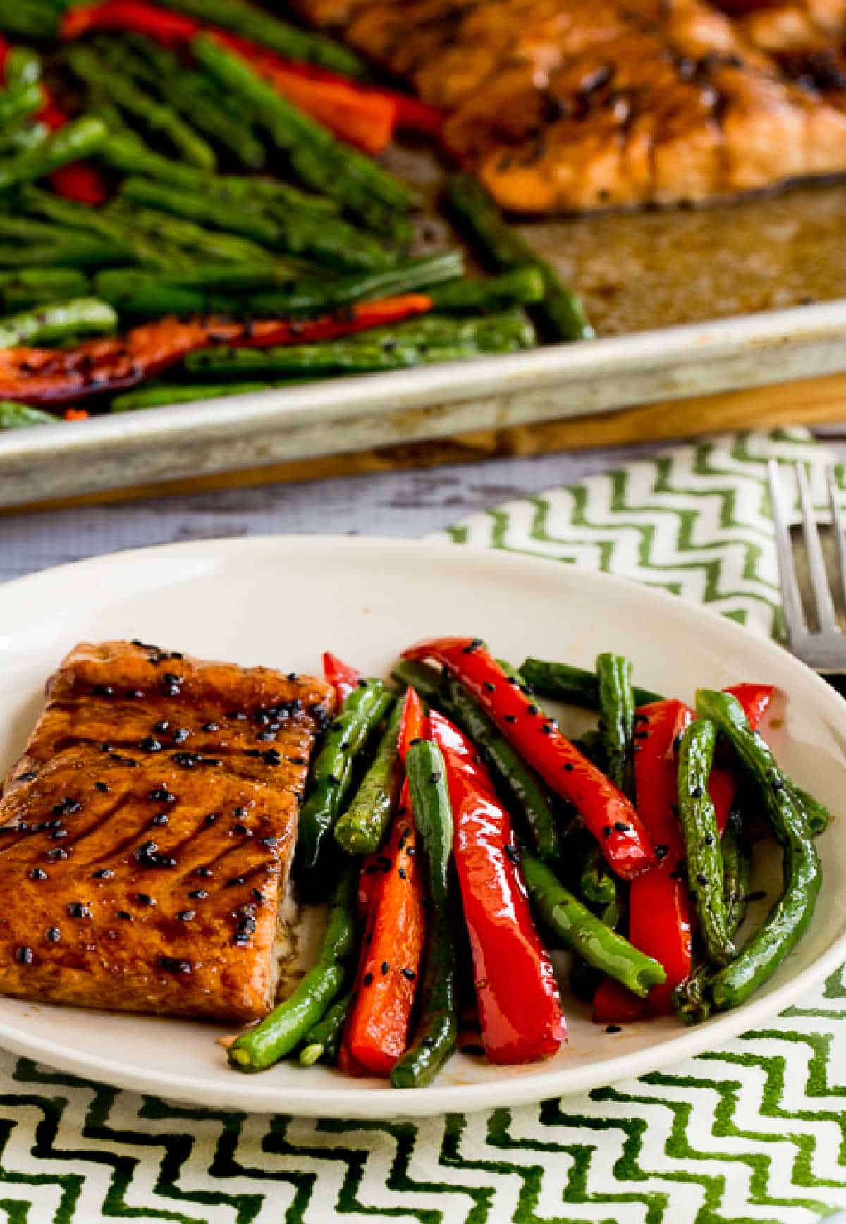 Asian Salmon and Green Beans Sheet Pan Meal with close-up of meal on plate and sheet pan in background