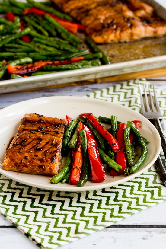Asian Salmon and Green Beans Sheet Pan Meal shown with one serving on plate and sheet pan meal in backgorund