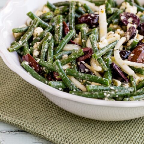 Green Bean Salad with Greek Olives and Feta Cheese shown in serving bowl with napkin