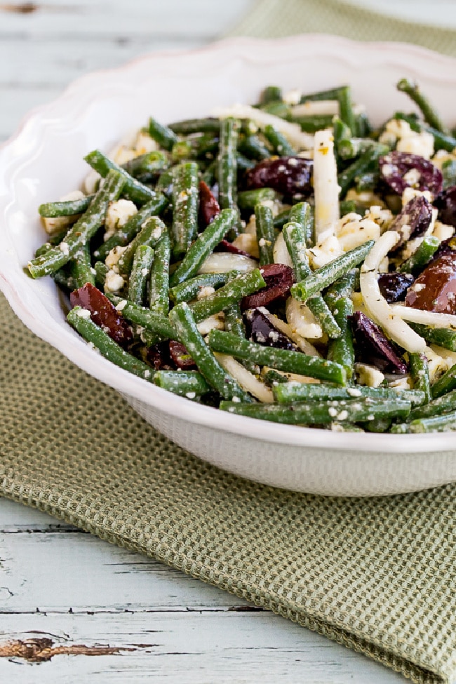 Green Bean Salad with Greek Olives and Feta Cheese shown in serving bowl with napkin