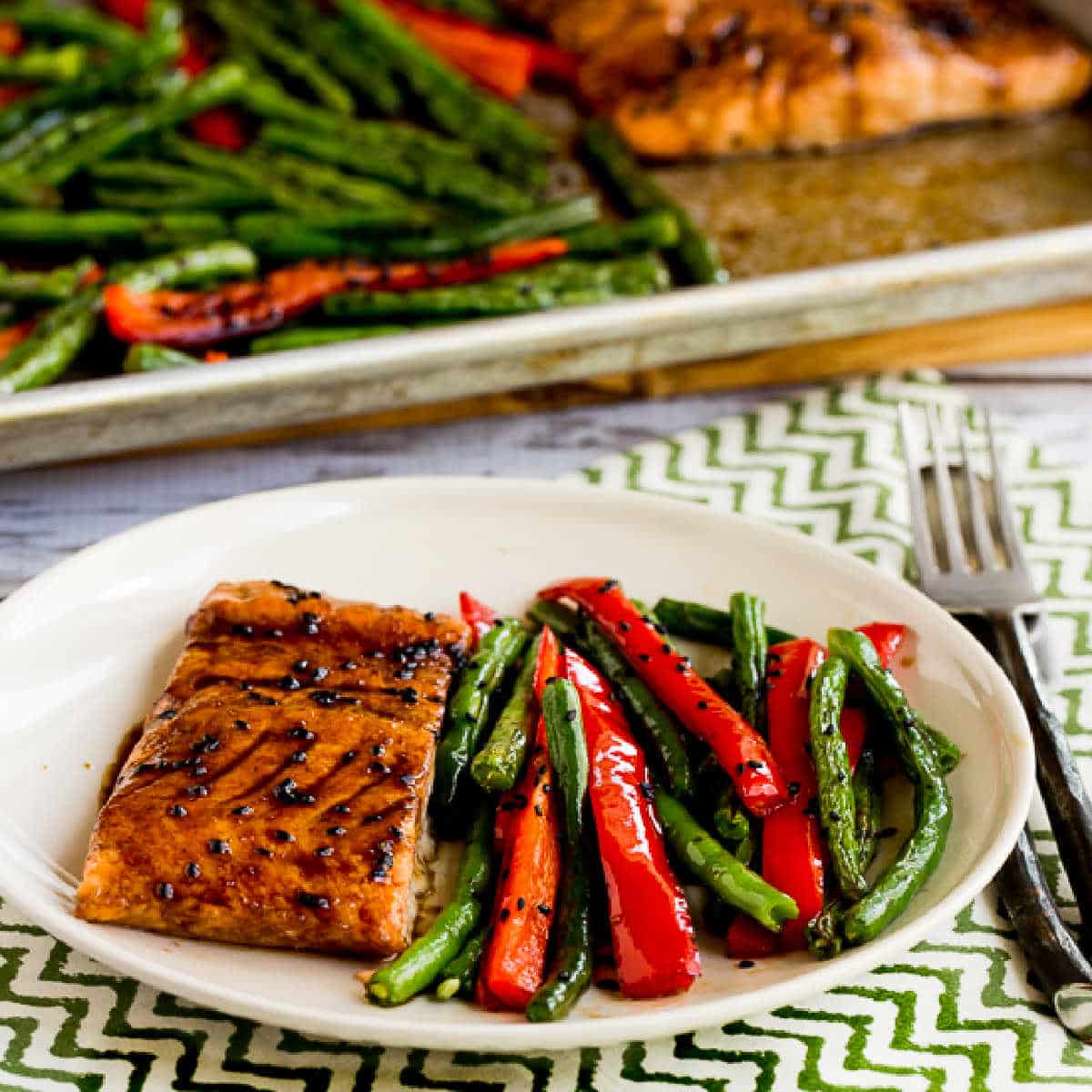 Asian Salmon and Green Beans Sheet Pan Meal  shown on serving plate with sheet pan in background.