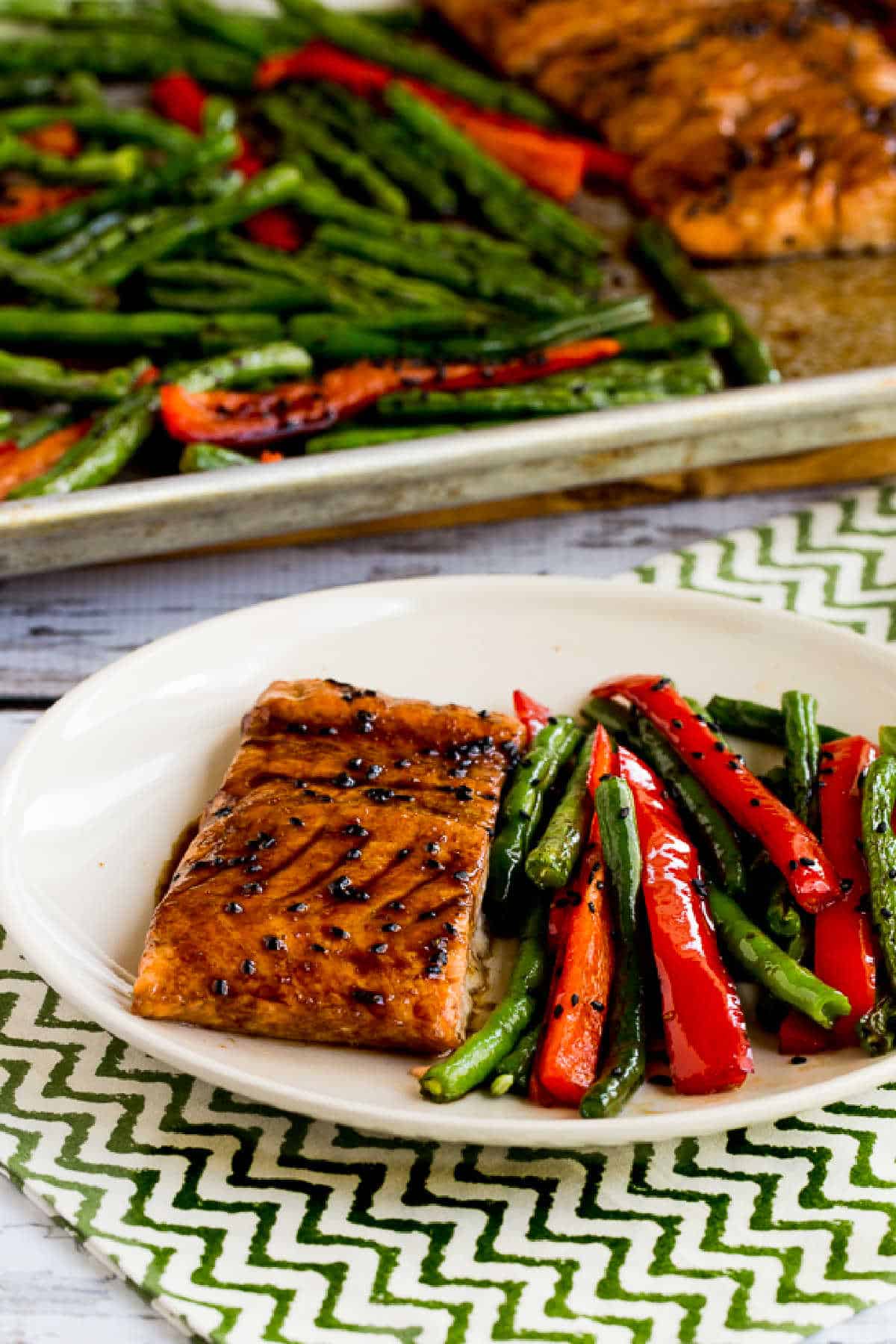 Asian Salmon and Green Beans Sheet Pan Meal with one dinner on plate and sheet pan in background