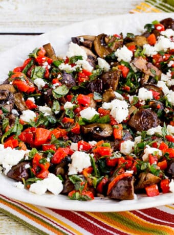 square image for Greek Style Roasted Mushrooms on serving plate with striped napkin