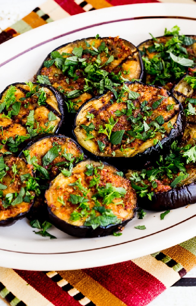 Spicy Grilled Eggplant shown on serving plate, sprinkled with fresh mint