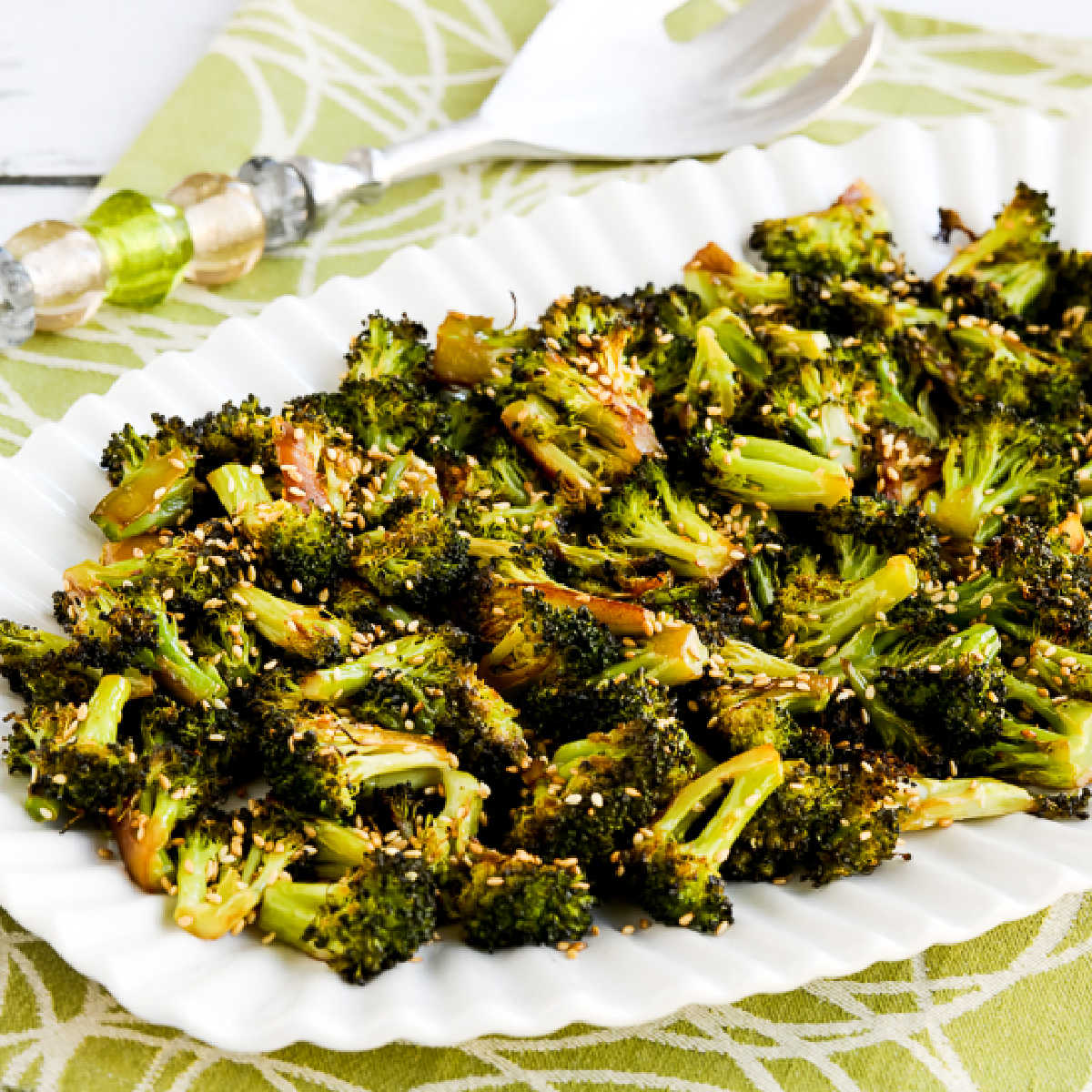 Quick roasted broccoli with soy sauce and sesame seeds displayed on a serving plate, square image