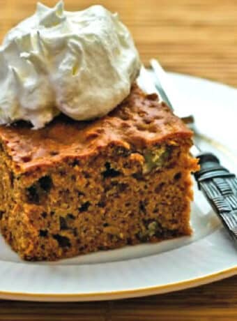 Square image of Apple Pear Cake shown on plate with whipped cream.