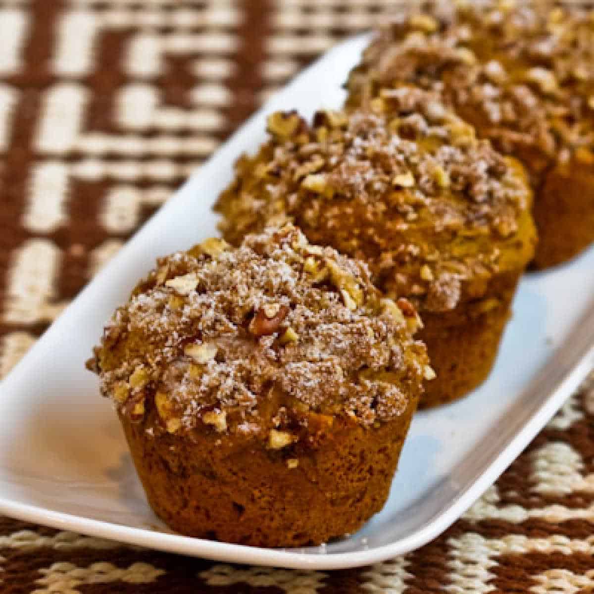 Muffin di zucca integrali senza zucchero che mostrano tre muffin su un piccolo vassoio