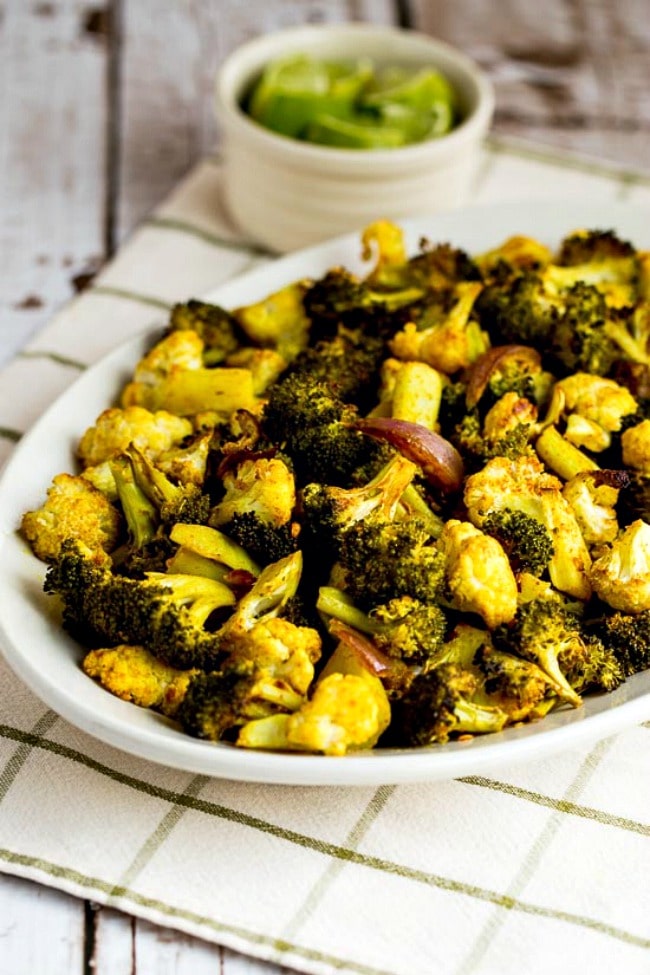 Slow roasted broccoli and cauliflower with curry on a serving plate