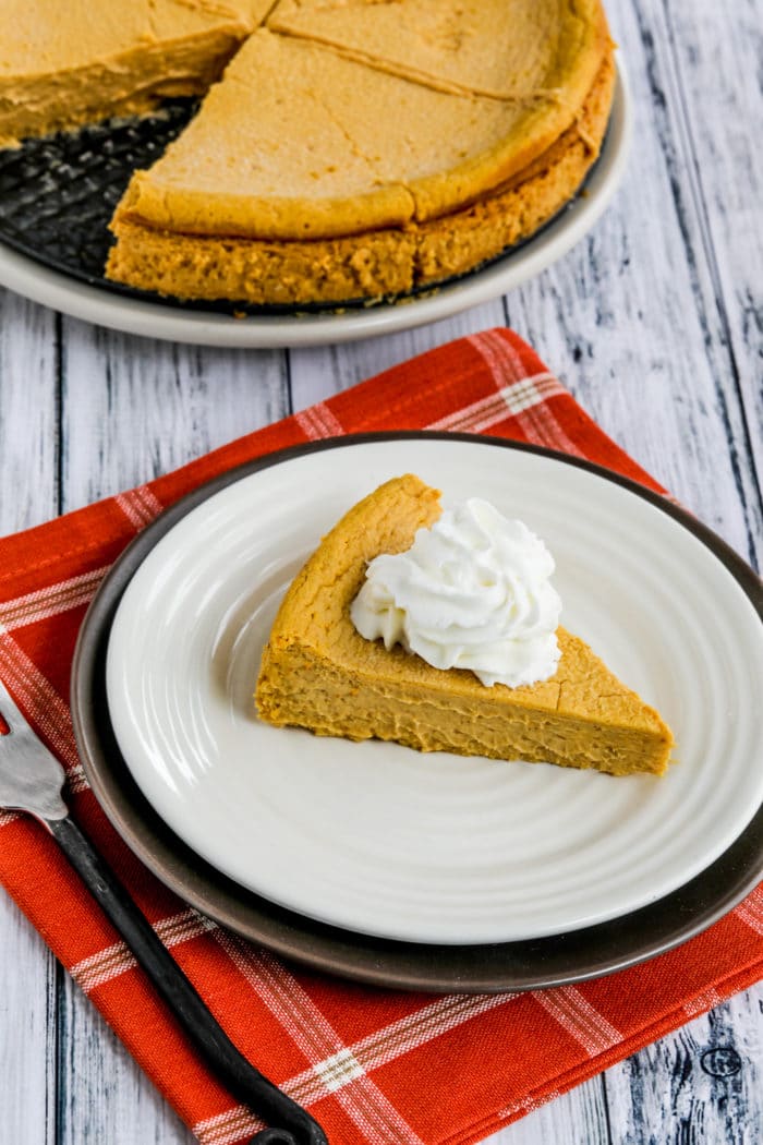 Sugar-Free Pumpkin Cheesecake Pie shown on serving plate with rest of pie in background