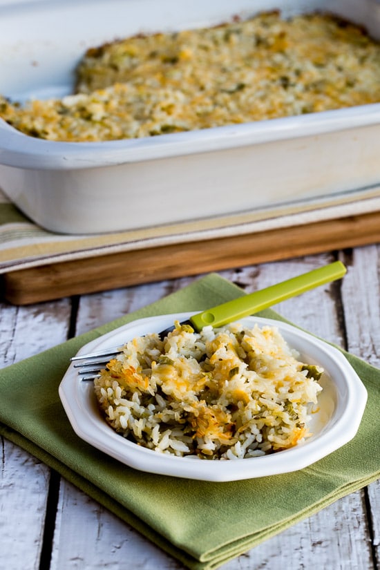 Slow Cooker Rice Casserole with Green Chiles and Cheese show in casserole crock-pot with one serving on plate
