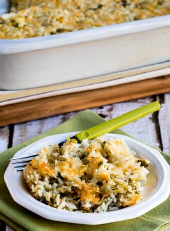 Slow Cooker Rice Casserole shown in casserole croc-pot with one serving on plate
