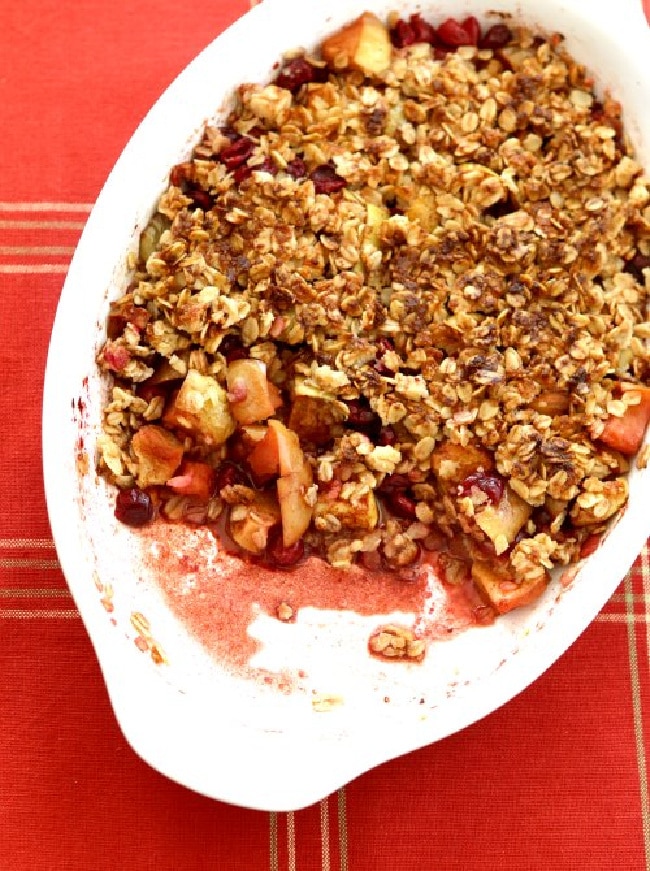Cranberry Apple Crisp in baking dish with one serving gone