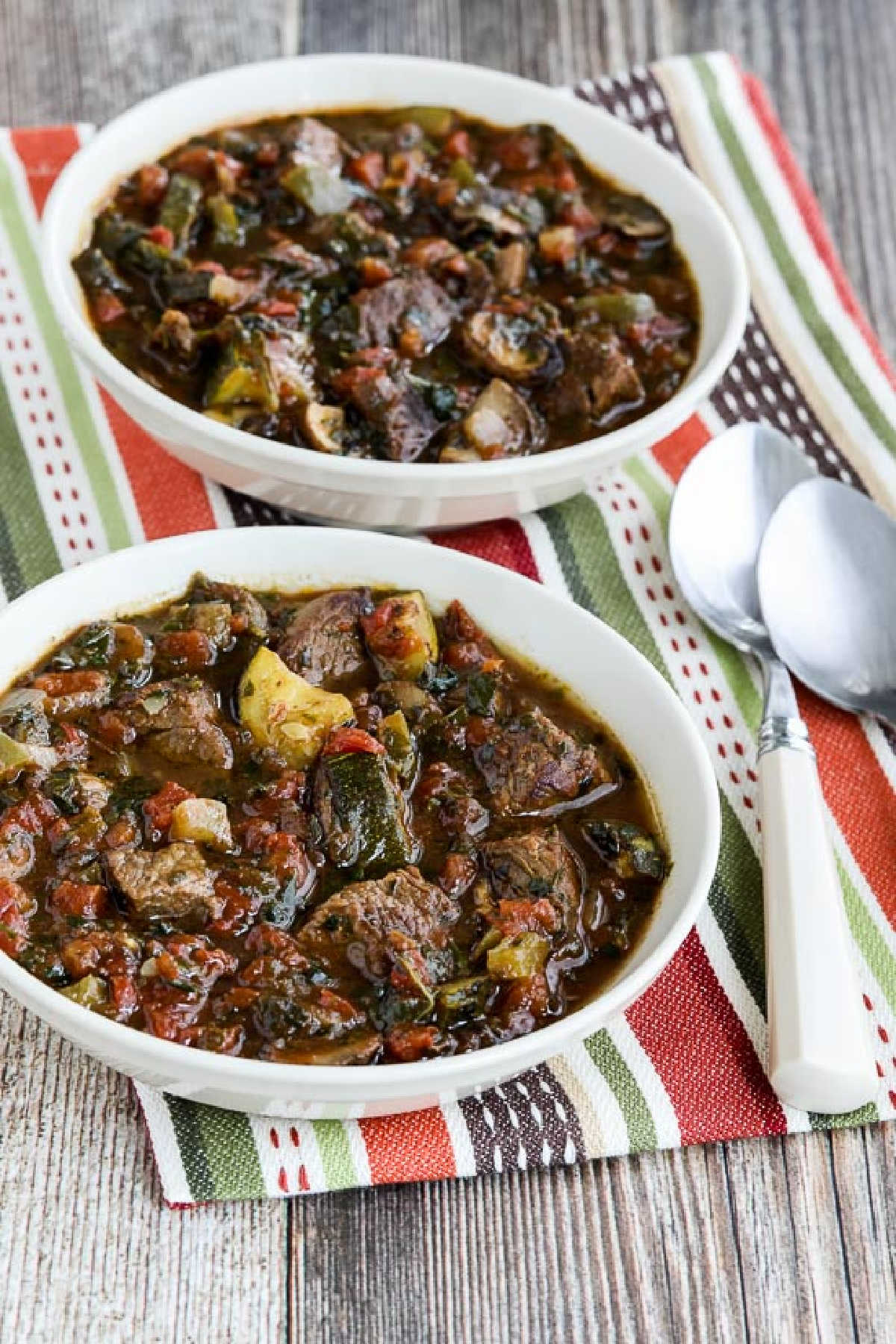 Italian Beef Stew with Zucchini, Mushrooms, and Basil shown in two serving bowls with spoons